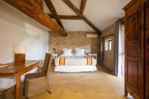 Un dormitorio con una cama y un escritorio en una habitación. en Le Galinier Lourmarin, a Beaumier Guesthouse, en Lourmarin 119 fotos más