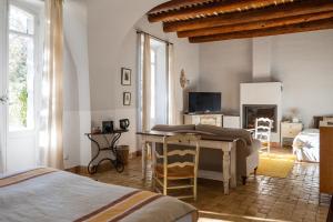 Un dormitorio con una cama, un escritorio y un televisor. en Le Galinier Lourmarin, a Beaumier Guesthouse, en Lourmarin