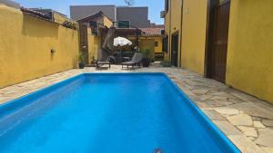 a blue swimming pool in the courtyard of a building at Pousada Bella Juquehy in Juquei
