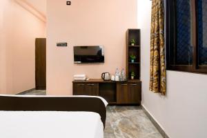 a hotel room with a bed and a tv at Hotel O M H Club And Resorts in Rānchī