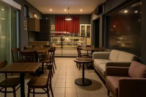 a restaurant with a couch and tables and a kitchen at Jams Hostel - Pousada perto da Ufcat in Catalão