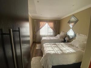 a hotel room with two beds and a window at Possiblerest Guesthouse in East London