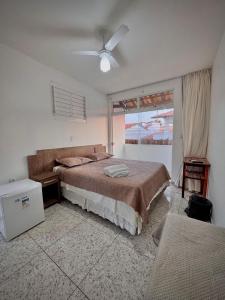 a bedroom with a bed and a ceiling fan at Pousada Kalango Flecheiras in Trairi