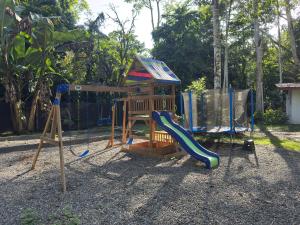 a playground with a slide and a swing set at El Rincon de la Suiza in Cahuita