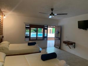 a bedroom with two beds and a flat screen tv at Hotel Tekal del Rio in Puerto Boyacá