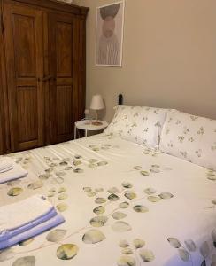 Una cama con pétalos de flores en un dormitorio en Casa di Gea, en Biella