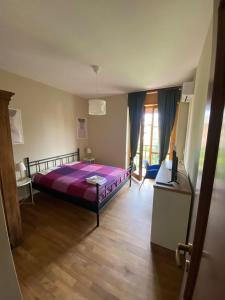 Un dormitorio con una cama grande con una manta morada. en Casa di Gea, en Biella