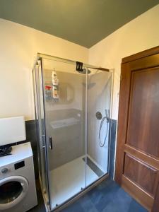 y baño con cabina de ducha y lavadora. en Casa di Gea, en Biella