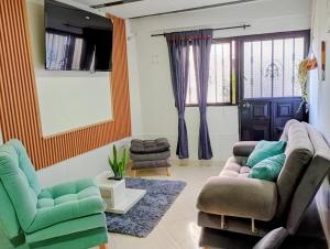 a living room with two chairs and a couch at Sweet Home in Curití
