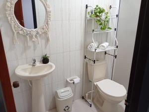 a bathroom with a sink and a toilet and a mirror at Sweet Home in Curití +23 photos