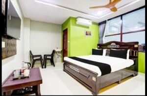 Un dormitorio con una cama y una pared verde. en Savoygrandluxuryrooms, en Warangal