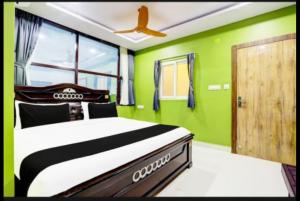 Un dormitorio con una cama con paredes y techo verdes. en Savoygrandluxuryrooms, en Warangal