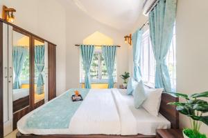 Schlafzimmer mit einem großen Bett und blauen Vorhängen in der Unterkunft Lavish 3bhk villa by bluewave hospitalty in Nagoa-Bardez