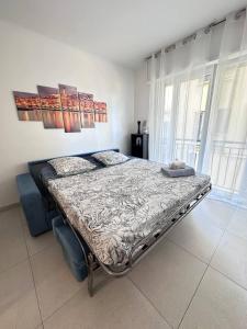 a bedroom with a bed in a room with windows at L'Espadon - vue mer, proche plage et gare in Menton