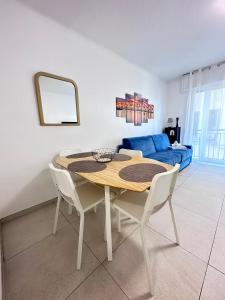 a dining room table with two chairs and a blue couch at L'Espadon - vue mer, proche plage et gare in Menton