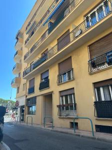 a building with balconies on the side of a street at L'Espadon - vue mer, proche plage et gare in Menton