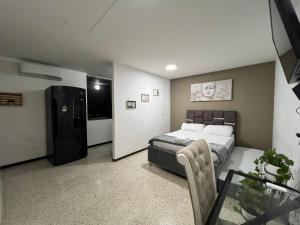 a bedroom with a bed and a refrigerator at APARTAMENTO ESTADIO in Cali