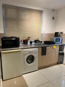 a kitchen with a washing machine and a microwave at Good Heart in Birmingham +3 photos