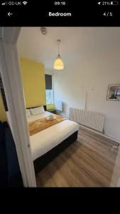 a bedroom with a large bed with a yellow headboard at Good Heart in Birmingham