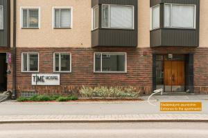 ユヴァスキュラにあるTime Hostel CITY - Jyväskyläの「タイムホテル」と書かれた看板のあるレンガ造りの建物