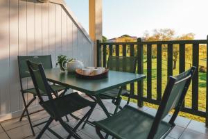 d'une table et de chaises sur un balcon avec une clôture. dans l'établissement Appartement vue golf - résidence Saint Laurent - 4 personnes, à Talmont-Saint-Hilaire