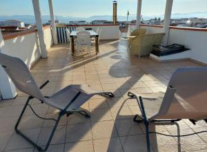 Un patio con sillas y una mesa en un tejado. en Casa Susanna, en Calasetta 14 fotos más