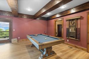 a pool table in a room with red walls at Cardinal Perch in Beech Mountain