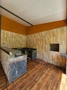 una stanza vuota con un bancone in pietra e pavimenti in legno di chacara Recanto do lazer a Pirenópolis