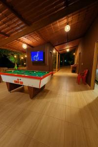 un soggiorno con tavolo da biliardo e TV di chacara Recanto do lazer a Pirenópolis