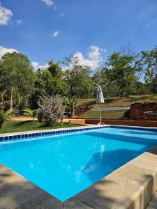 una grande piscina blu in un cortile di chacara Recanto do lazer a Pirenópolis