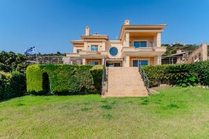 une grande maison avec un escalier devant elle dans l'établissement Anemou Nota Villa-Luxury Resort, à Ambelón