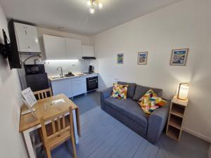 a living room with a couch and a kitchen at Appartement F2 5A in Martres-de-Veyre