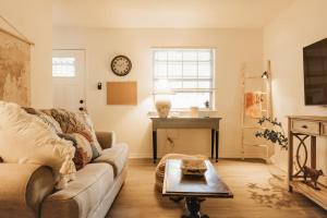 una sala de estar con un sofá y una mesa en WabiSabi ATX Garden Gem at SoCo, Antique, Cloud Beds, Pool, Shops & Eats, en Austin