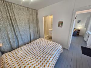 a bedroom with a bed with a checkered blanket at Appartement F2 5A in Martres-de-Veyre +4 photos