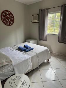 a bedroom with a bed with blue towels on it at Casa Maju Suítes in Búzios +7 photos