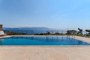 une grande piscine avec vue sur l'eau dans l'établissement Anemou Nota Villa-Luxury Resort, à Ambelón