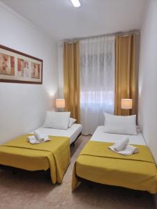 2 letti in una stanza con cuscini gialli di Happy House - Central Apartment a Faro