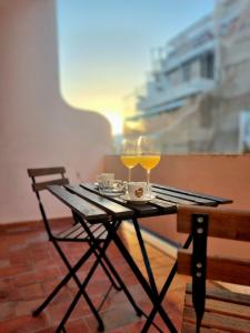 un tavolo da picnic con due bicchieri di vino sopra di Happy House - Central Apartment a Faro Altre 42 foto