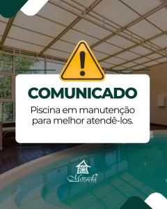 Un cartel para una piscina con una señal de advertencia en Hotel Morada Del Este, en Canoas