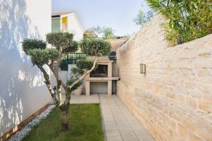 a brick wall with a tree in a courtyard at ZK luxury Villa in Murter