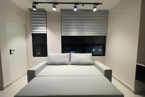 a white bed in a room with two windows at Sophisticated APT Parking Work Gym BBQ WiFi MTY in Monterrey +22 photos