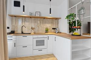 a kitchen with white cabinets and a wooden counter top at Cozy living in Gießen - free parking - balcony in Gießen
