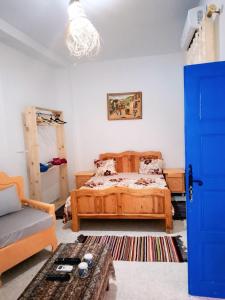 a bedroom with a bed and a blue door at Dar Aziz VIP in Sousse