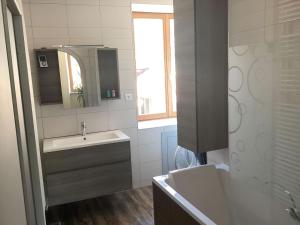 a white bathroom with a sink and a mirror at Gîte La Bandsäge rando,rivière,quietude 