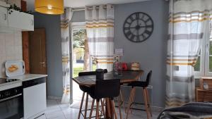 Una cocina con una mesa y un reloj en la pared. en La P'tite Maison..., en Sickert 30 fotos más