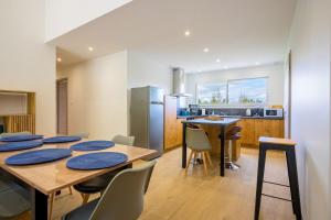 Una cocina y un comedor con mesa y sillas. en Ma bonne étoile, en Anould