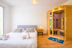 a bedroom with a white bed and a wooden cabinet at Ma bonne étoile in Anould