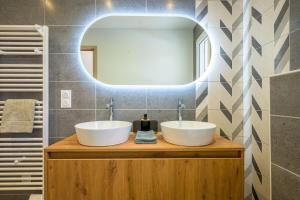 a bathroom with two sinks and a mirror at Ma bonne étoile in Anould +27 photos