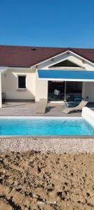 a swimming pool in front of a house at Ma bonne étoile in Anould