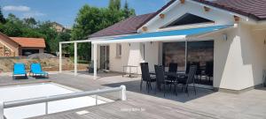 Un patio con una mesa y sillas en una terraza. en Ma bonne étoile, en Anould